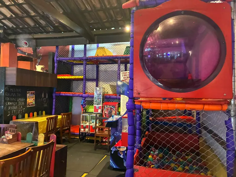 O playground de Santa Inês, com a bolha vermelha, o circuito e a piscina de bolinhas, do lado das mesas